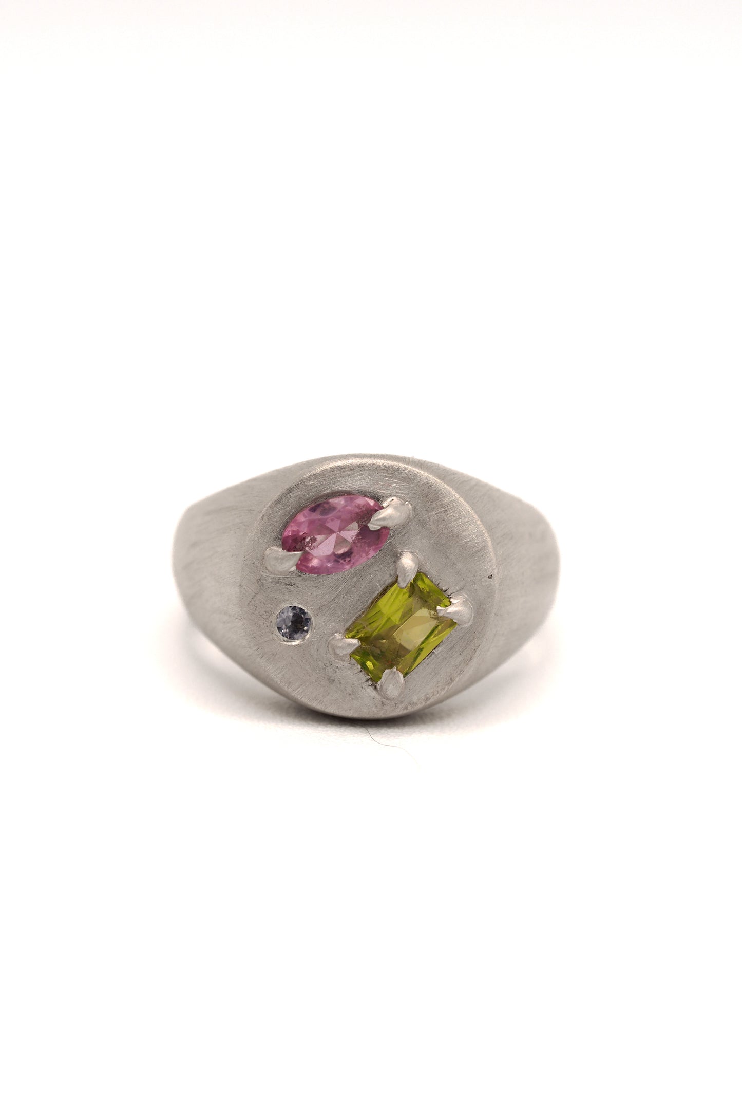 Silver ring with embedded gemstones on a white background
