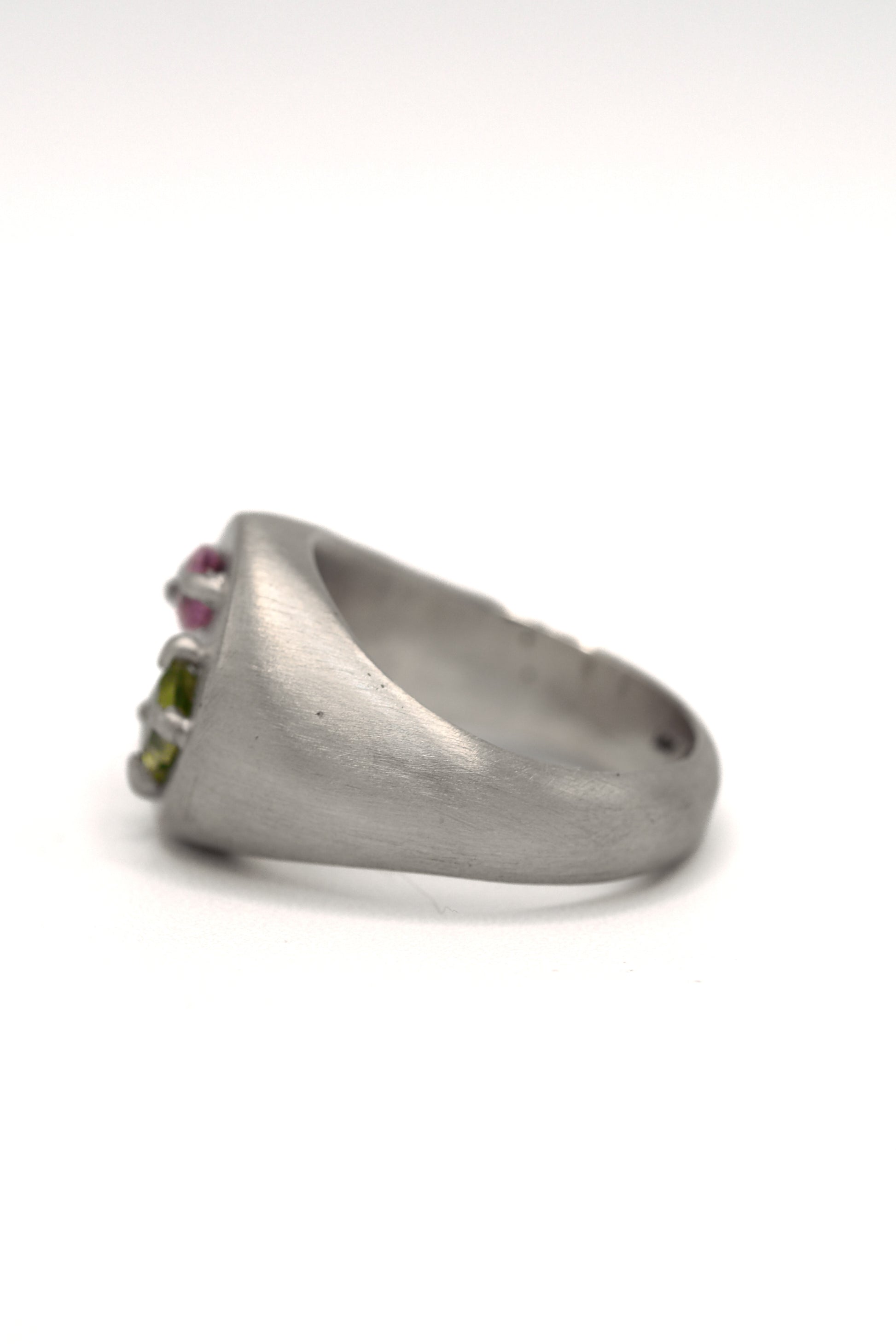 Silver ring with embedded gemstones on a white background